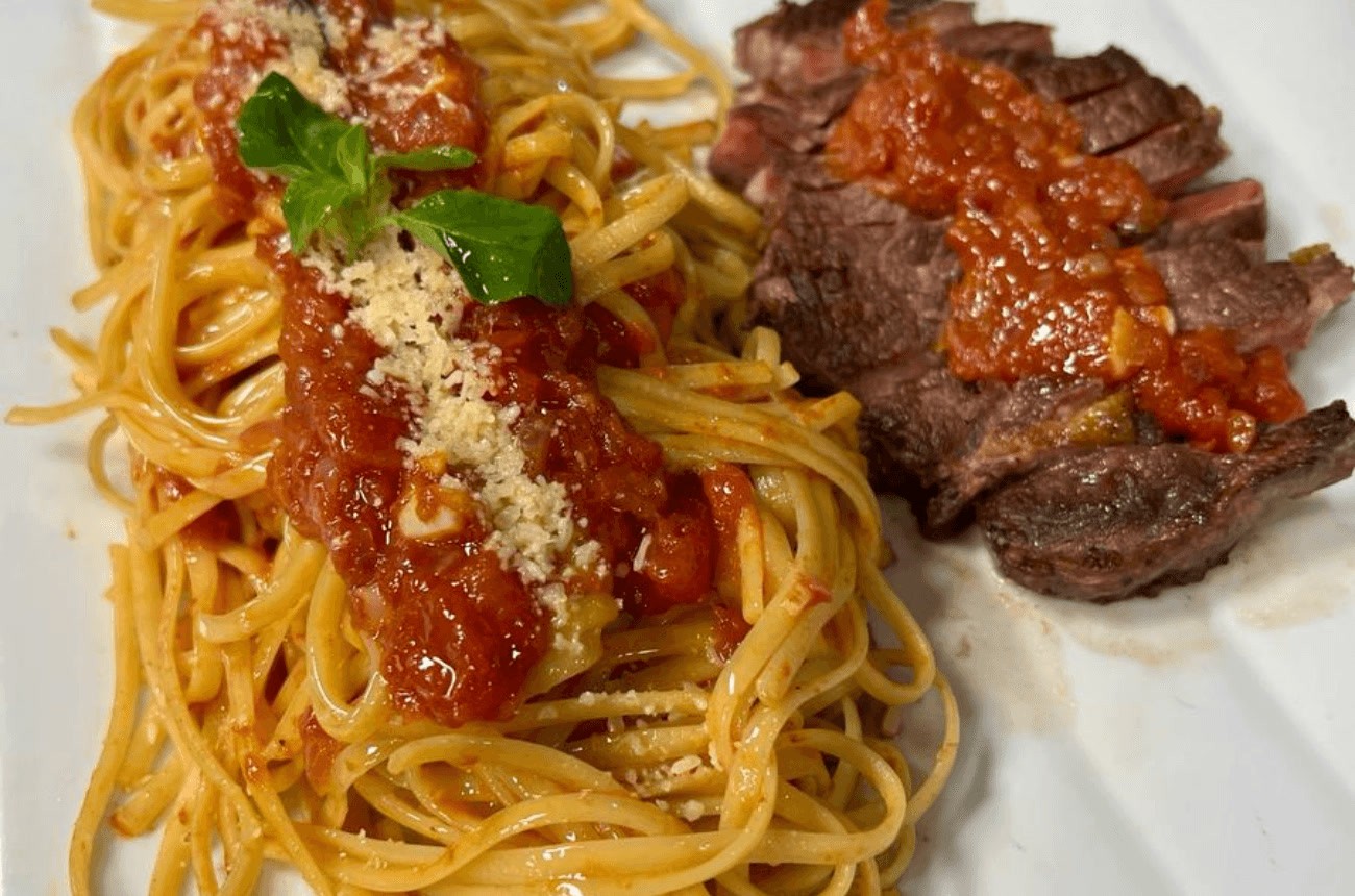 Carne grelhada fatiada com espaguete ao molho de tomate Carne grelhada fatiada com espaguete ao molho de tomate