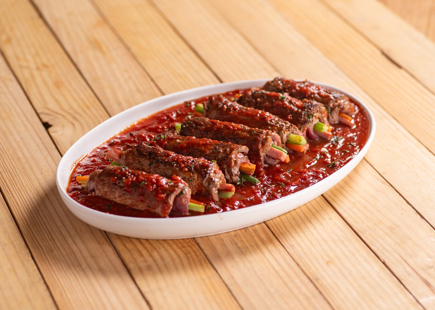 Enroladinhos de carne ao molho de tomate em travessa