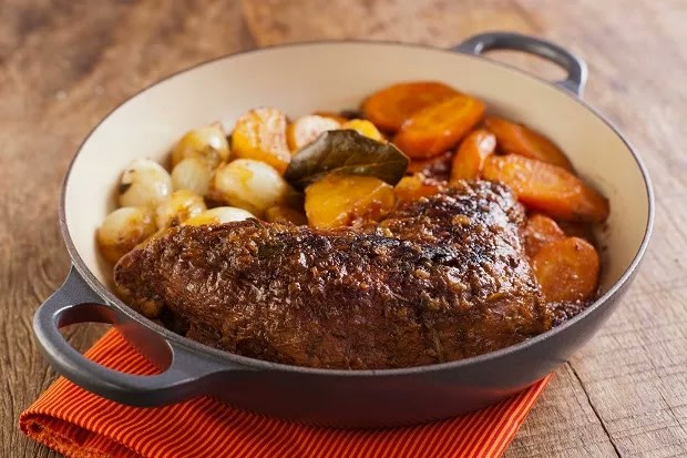 Peça de carne cozida com cenoura, batata e cebolinhas em panela Peça de carne cozida com cenoura, batata e cebolinhas em panela