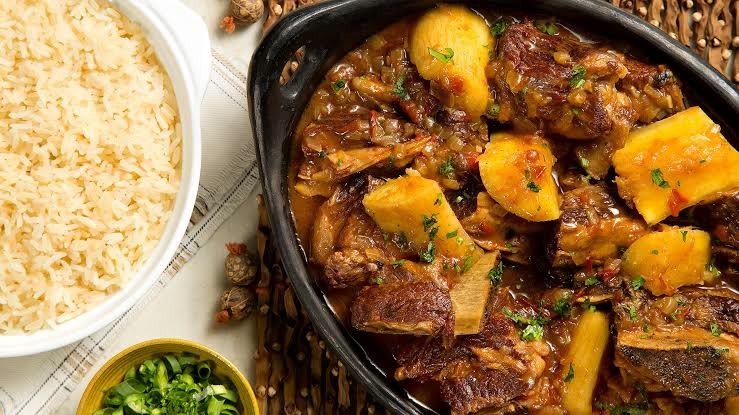 Costela cozida com mandioca em panela de barro, com arroz e cebolinha